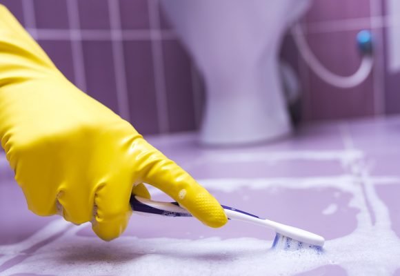 Hand,In,Yellow,Glove,Cleans,The,Tile,Toothbrush.